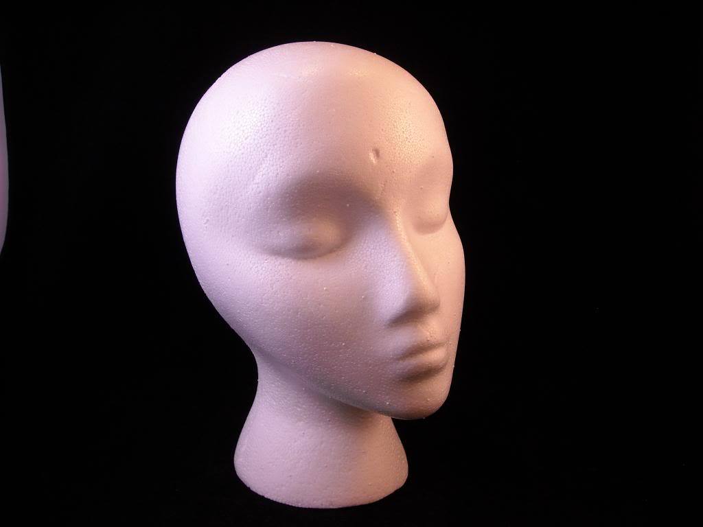White styrofoam model head holds hats
